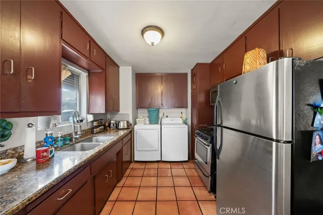 a kitchen with a refrigerator a sink and cabinets