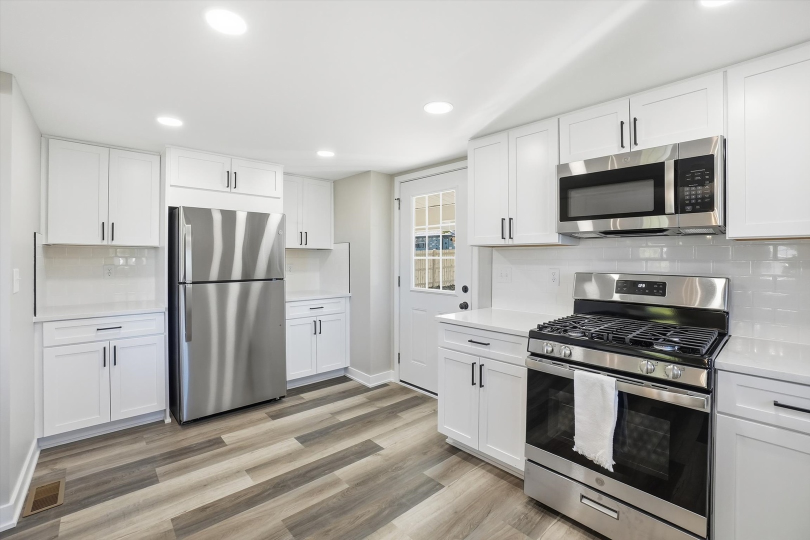 1313 Elizabeth Street Joliet, IL 60435 - Photo 10 of 27 a kitchen with stainless steel appliances granite countertop a refrigerator stove a sink and a white cabinets