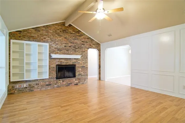 a view of an empty room with a fireplace and a window
