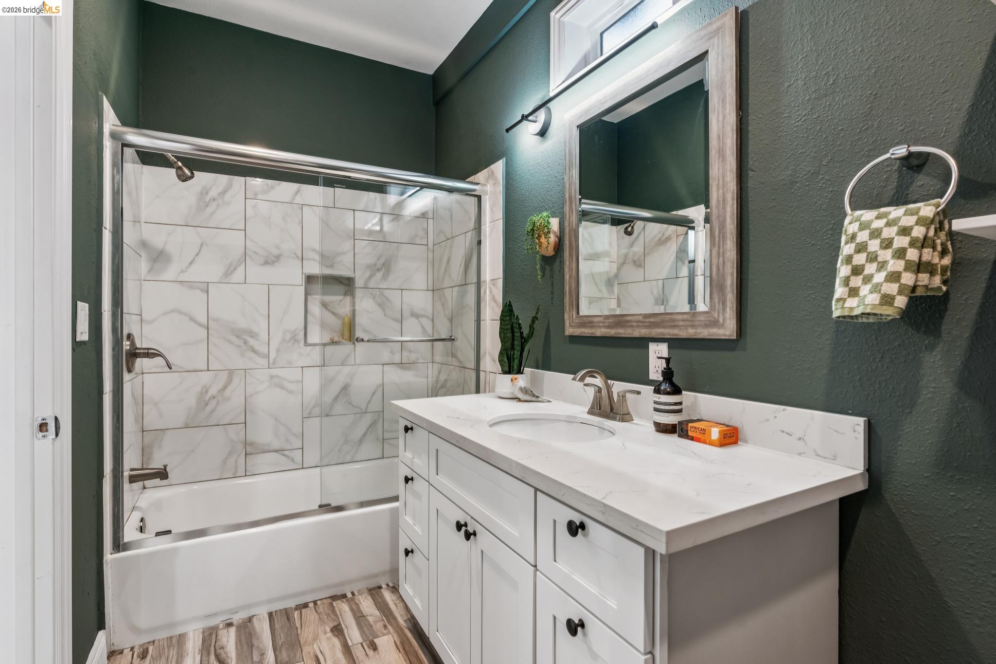 2010 Filbert Street Oakland, CA 94607 - Photo 21 of 50 Bathroom with a textured wall, vanity, bath / shower combo with glass door, and light wood-type flooring