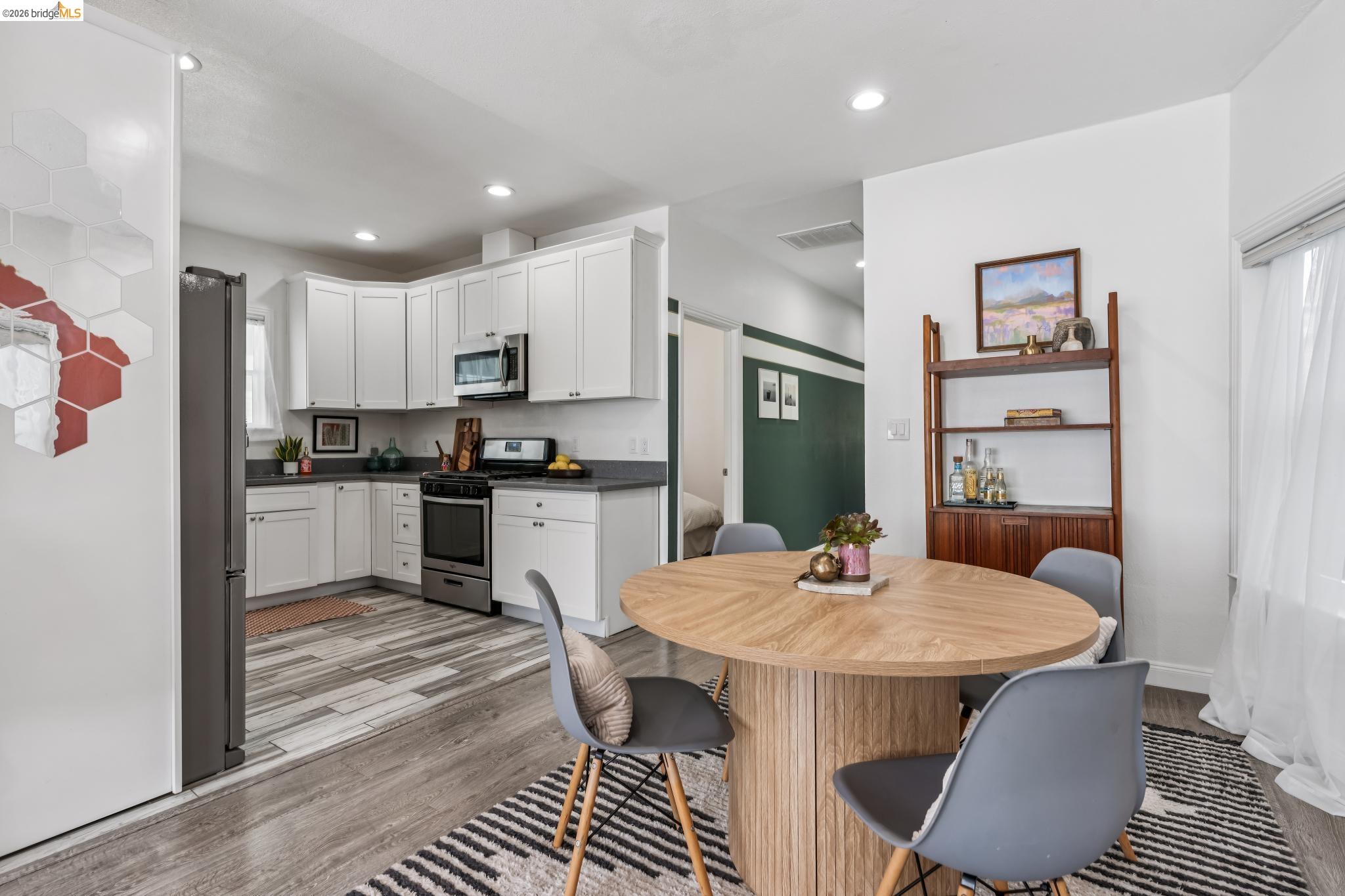 2010 Filbert Street Oakland, CA 94607 - Photo 7 of 50 Kitchen with stainless steel appliances, white cabinets, light wood-type flooring, dark countertops, and recessed lighting
