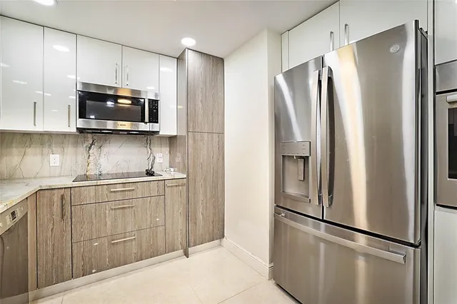 a kitchen with stainless steel appliances granite countertop a refrigerator a microwave a sink and cabinets