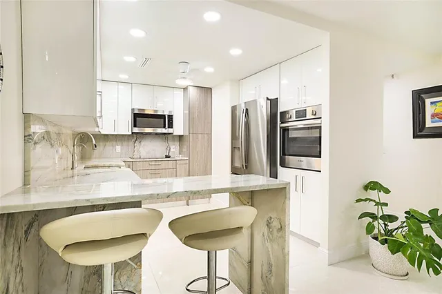 a kitchen with stainless steel appliances granite countertop a sink and a refrigerator