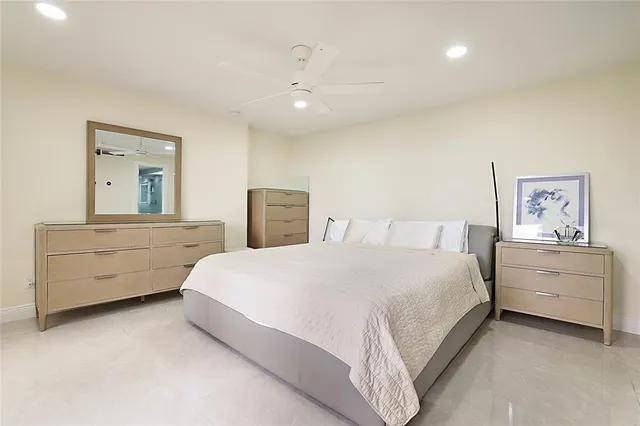 a spacious bedroom with a bed and a dresser