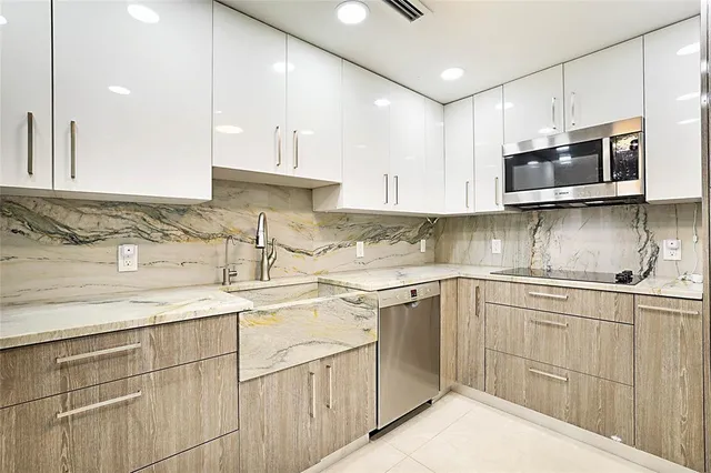 a kitchen with stainless steel appliances granite countertop a sink stove and microwave