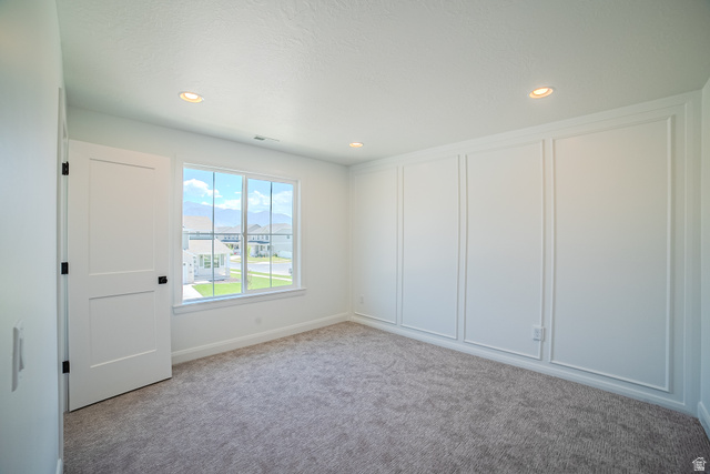 45 North Scarlet Maple Road, Unit 4317 Vineyard, UT 84059 - Photo 21 of 35 Interior room featuring a large window, plush gray carpet flooring, recessed lighting, white trim, and decorative wall paneling