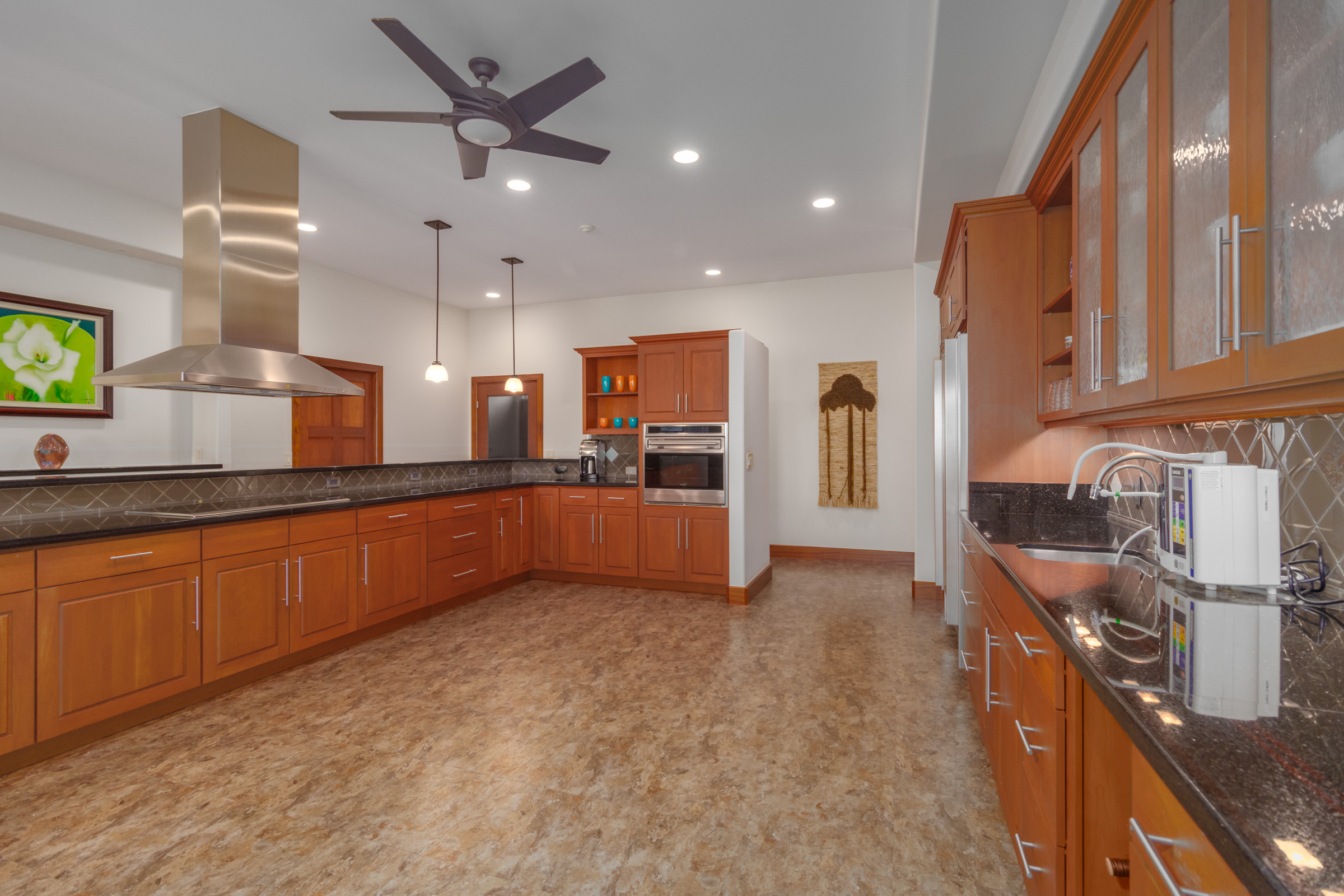 82-1171 Meli Road Captain Cook, HI 96704 - Photo 11 of 29 a large kitchen with stainless steel appliances kitchen island granite countertop a refrigerator and a stove top oven