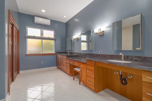 a bathroom with a sink a light fixture and a glass door shower