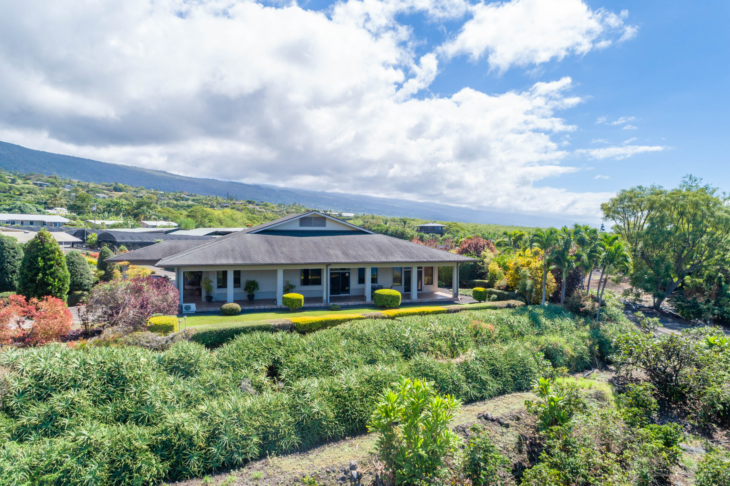 82-1171 Meli Road Captain Cook, HI 96704 - Photo 2 of 29 a view of a large building with a garden and plants