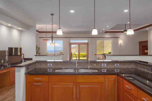 a large kitchen with stainless steel appliances kitchen island granite countertop a refrigerator and a stove top oven