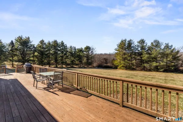 a balcony with wooden floor and outdoor seating