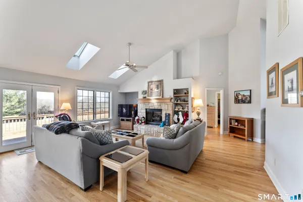 a living room with furniture kitchen view and a wooden floor