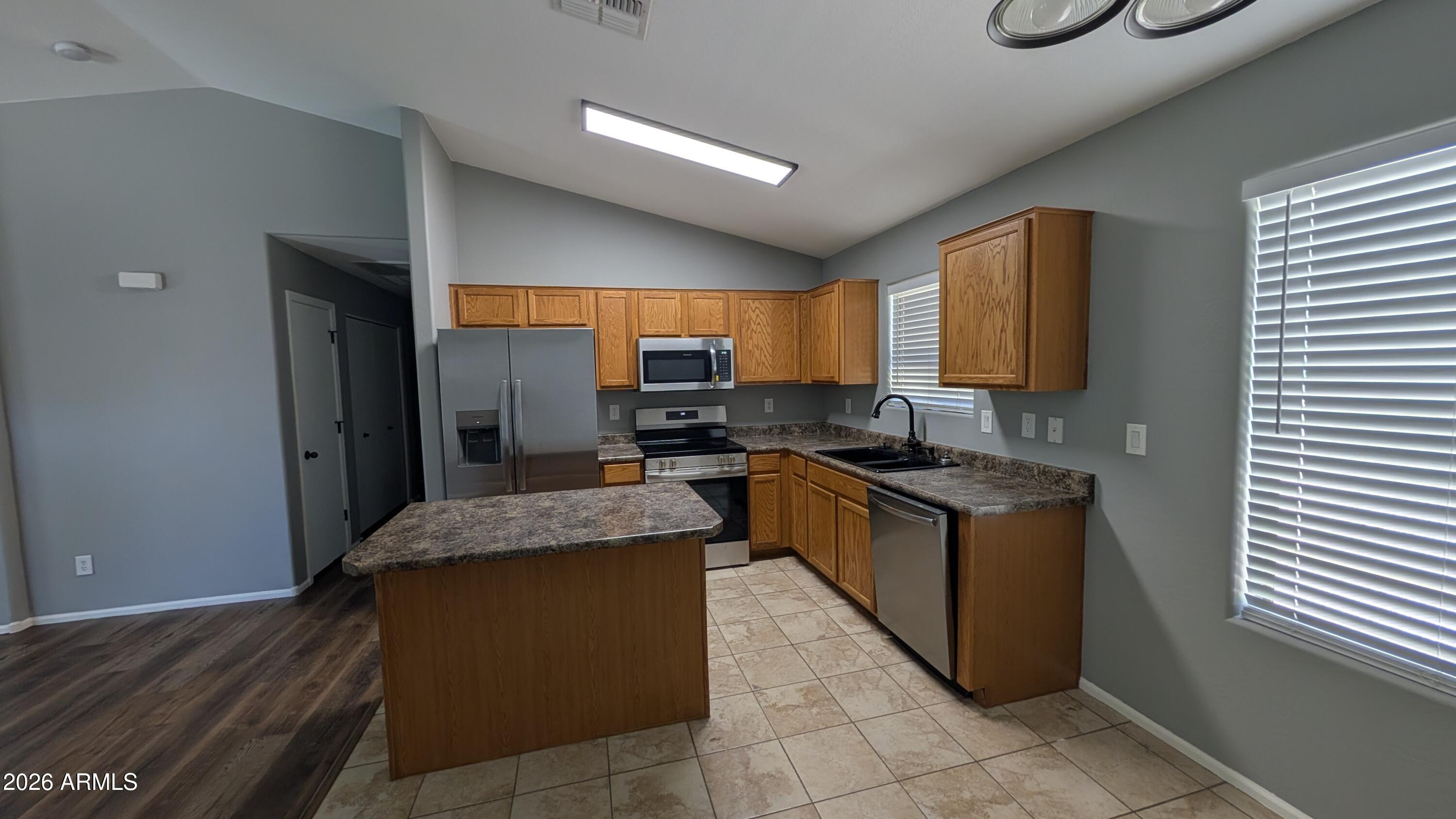 1377 East Pryor Road San Tan Valley, AZ 85140 - Photo 13 of 31 a kitchen with stainless steel appliances granite countertop wooden cabinets a sink and a stove