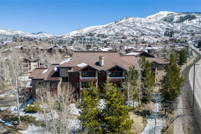 a view of a house with a mountain and trees in the background