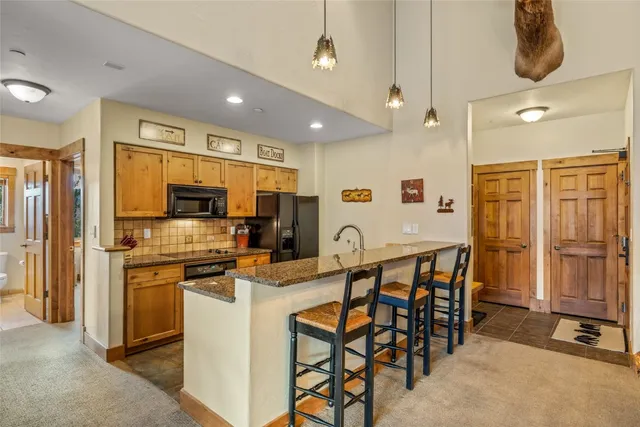 a kitchen with stainless steel appliances kitchen island granite countertop a refrigerator and microwave