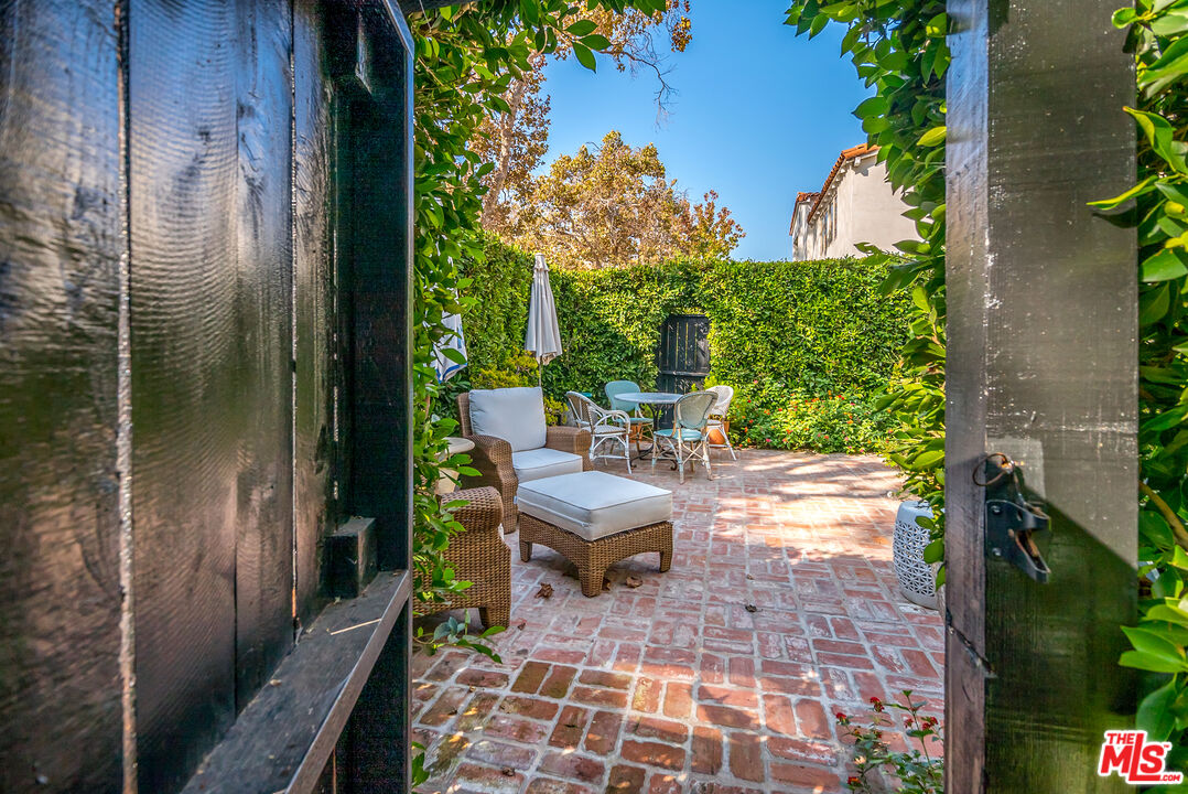 a view of a porch with chairs and potted plants