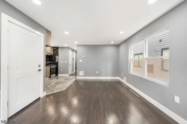 a view of a kitchen with wooden floor and a refrigerator