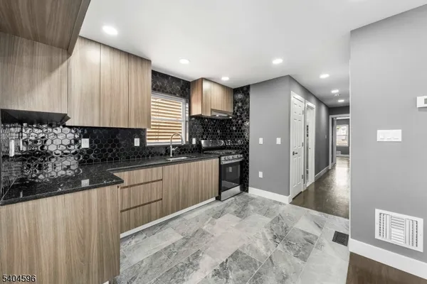 a kitchen with stainless steel appliances kitchen island granite countertop a refrigerator and a sink