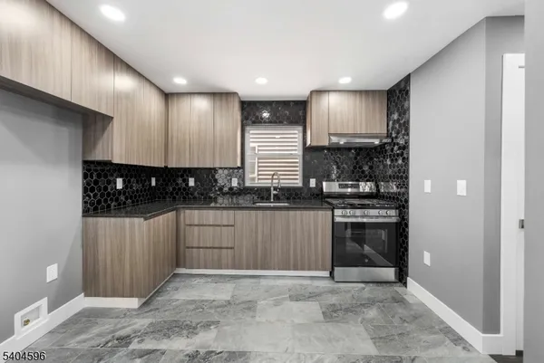 a kitchen with stainless steel appliances granite countertop a stove a sink and a refrigerator