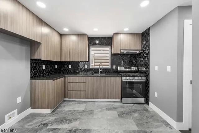 a kitchen with stainless steel appliances granite countertop a stove a sink and a refrigerator