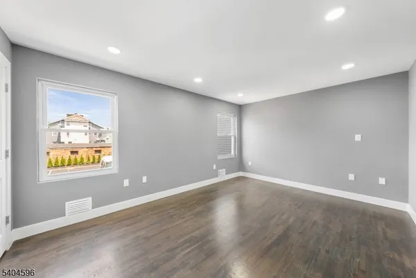 an empty room with windows and wooden floor
