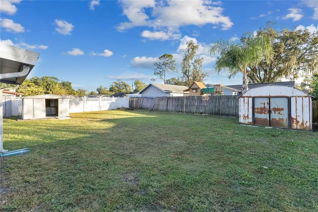 a view of a house with a big yard and large trees
