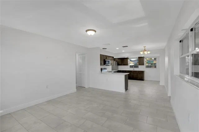 a view of kitchen with kitchen island sink and refrigerator