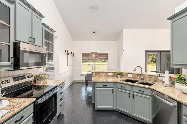 a kitchen with a sink stove top oven and microwave