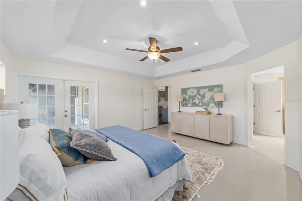 a bedroom with a large bed and a chandelier fan