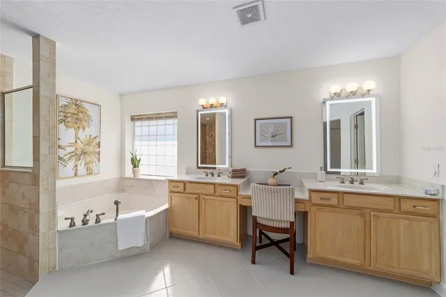 a bathroom with a granite countertop tub sink and mirror