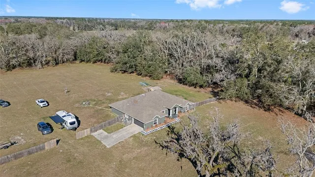 an aerial view of house with yard and mountain view in back