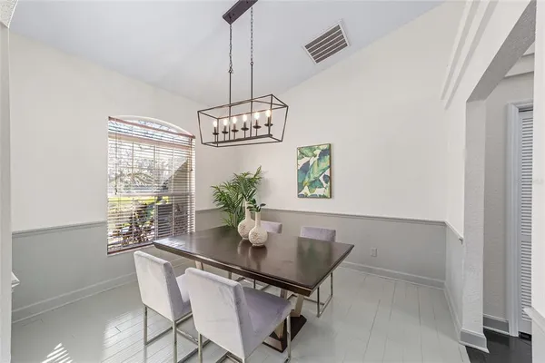 a view of a dining room with furniture a chandelier and wooden floor