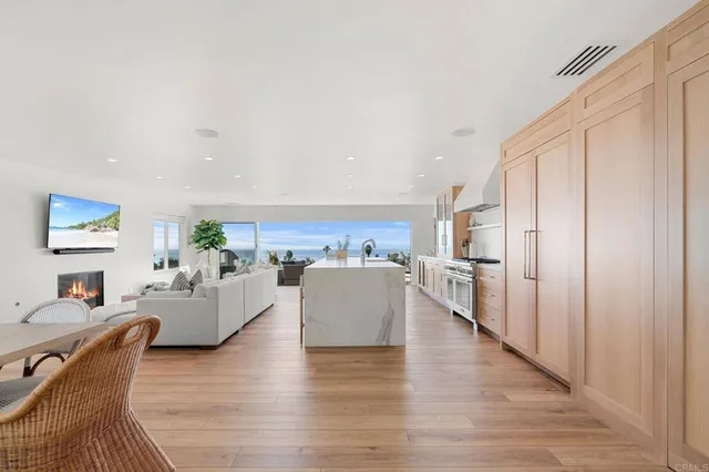 an open kitchen with dining table and wooden floor