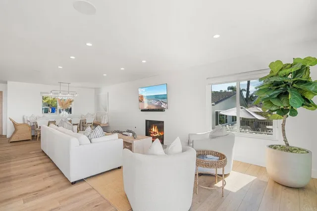 a living room with stainless steel appliances kitchen island granite countertop a couch and white cabinets
