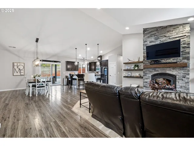 a living room with furniture a flat screen tv and a fireplace