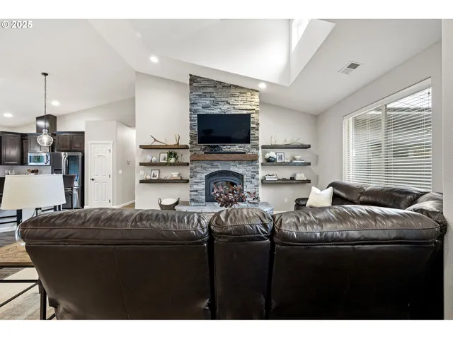 a living room with furniture kitchen and a flat screen tv