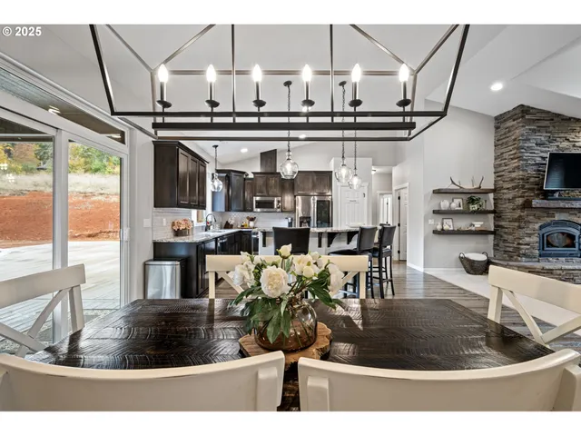 a living room with stainless steel appliances kitchen island granite countertop a table and chairs in it
