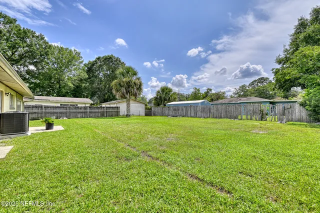 a view of yard with swimming pool and trees in the background