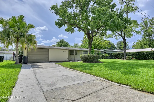 a front view of a house with a yard and a garage