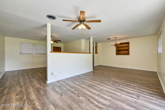 a view of empty room with wooden floor