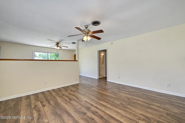 wooden floor in an empty room with a window