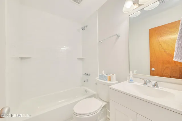 a bathroom with a toilet a sink a mirror a bathtub and shower