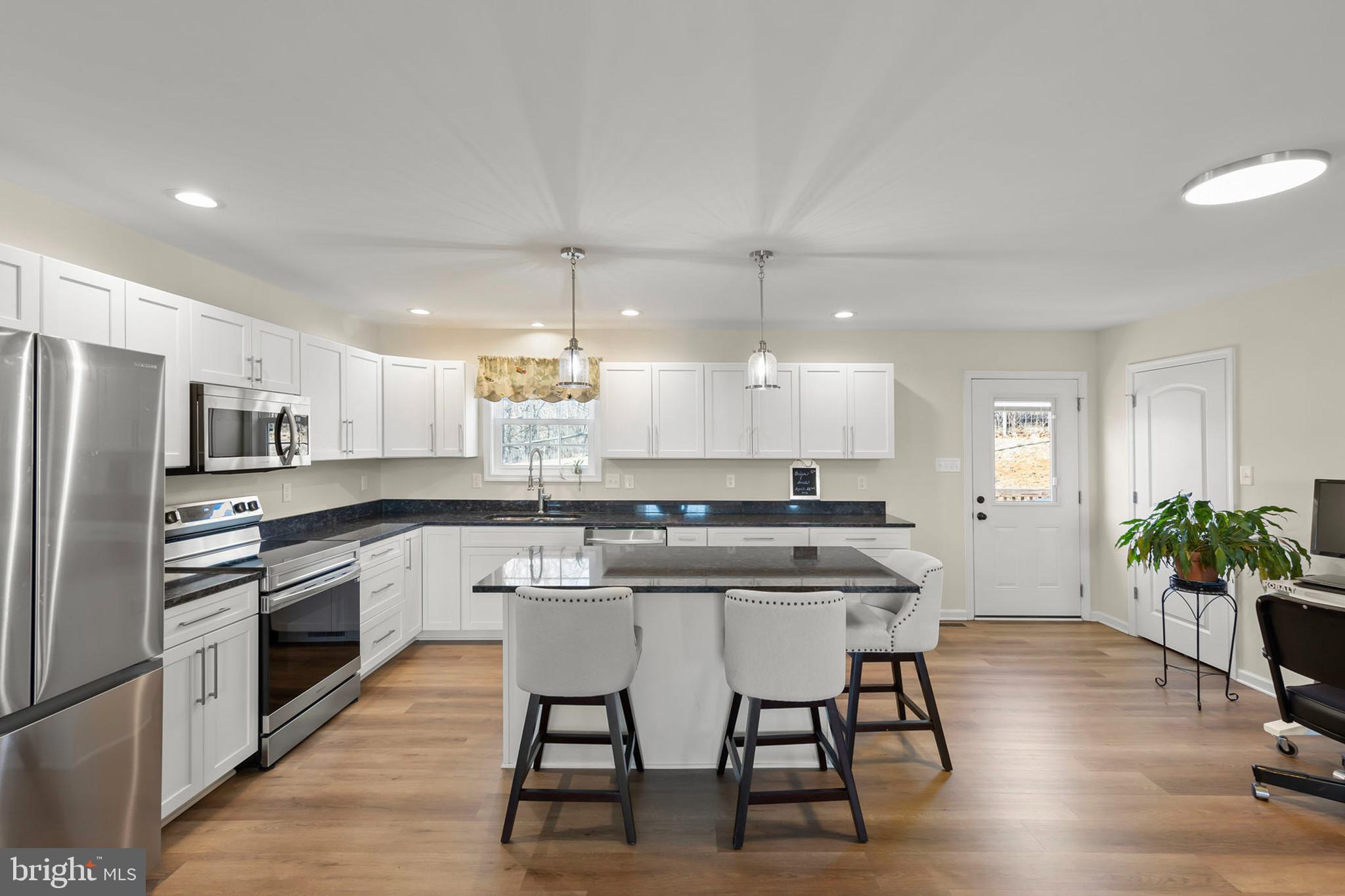 4009 Ridge Road Quicksburg, VA 22847 - Photo 4 of 41 a kitchen with stainless steel appliances a table chairs refrigerator and cabinets