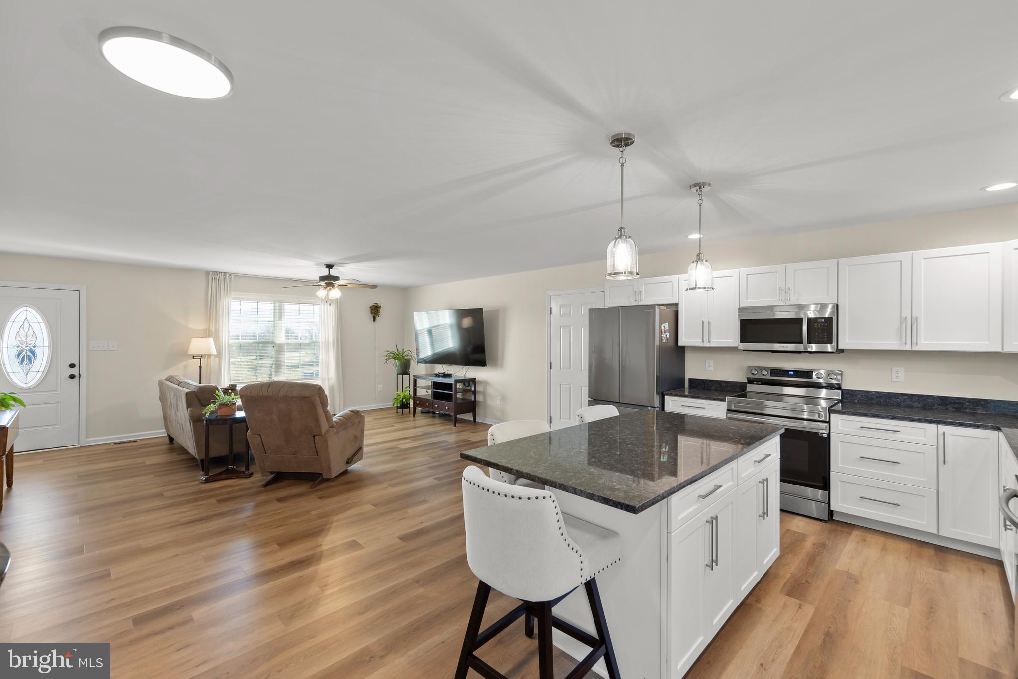4009 Ridge Road Quicksburg, VA 22847 - Photo 40 of 41 a kitchen with stainless steel appliances granite countertop a stove a sink dishwasher a refrigerator a microwave oven with white cabinets and wooden floor