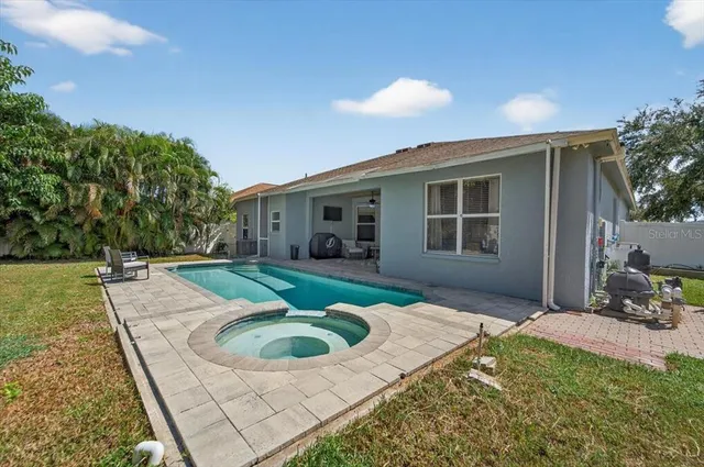 a view of a house with backyard and sitting area