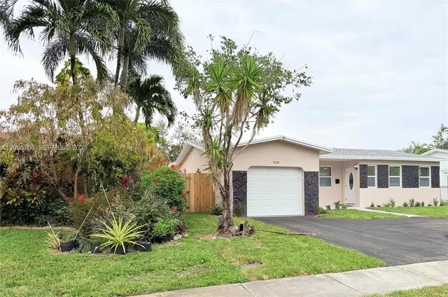 a front view of a house with a yard and potted plants