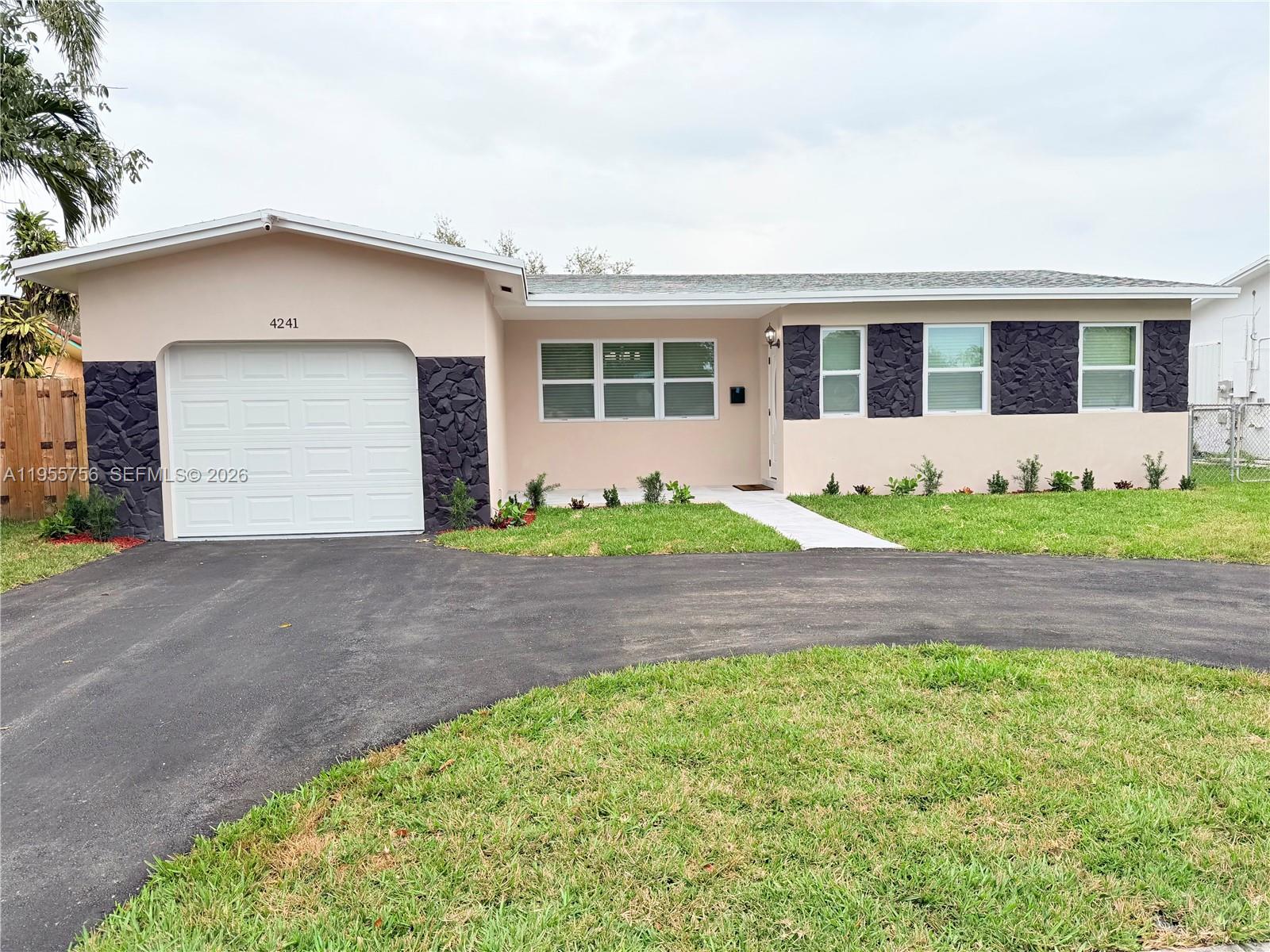 4241 Thomas Street Hollywood, FL 33021 - Photo 2 of 91 a front view of a house with a garden and yard