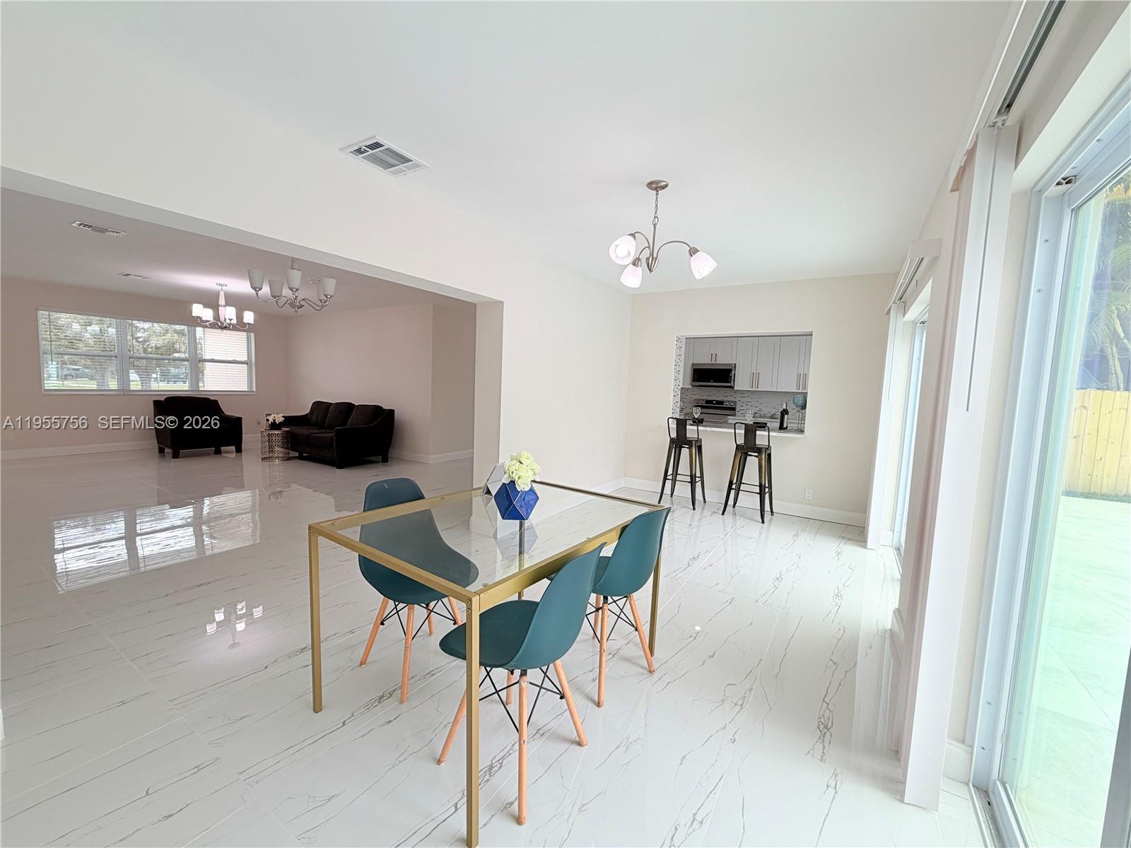 4241 Thomas Street Hollywood, FL 33021 - Photo 22 of 91 a view of a dining room with furniture and a chandelier