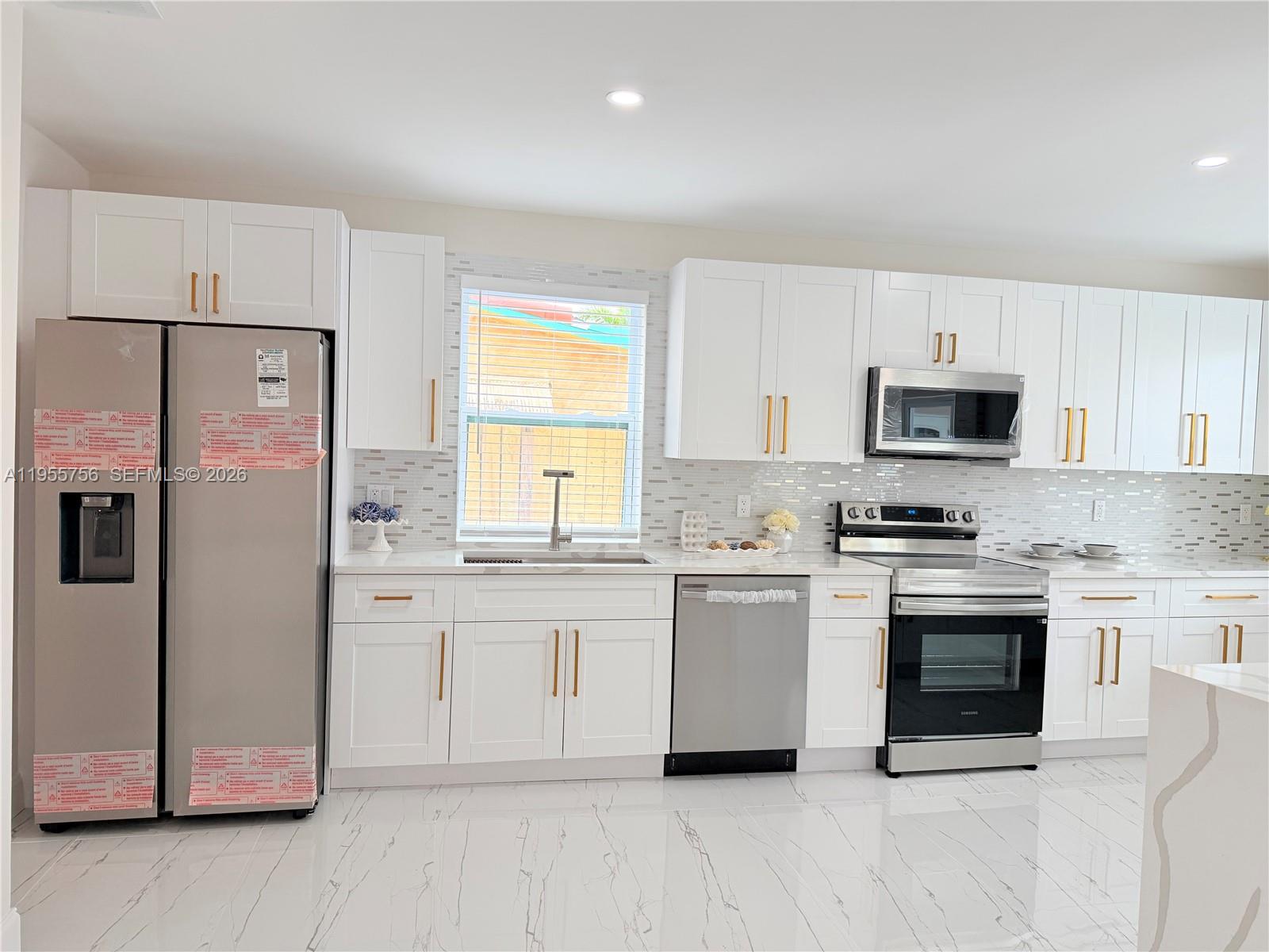4241 Thomas Street Hollywood, FL 33021 - Photo 28 of 91 a kitchen with stainless steel appliances granite countertop a stove a sink and a microwave