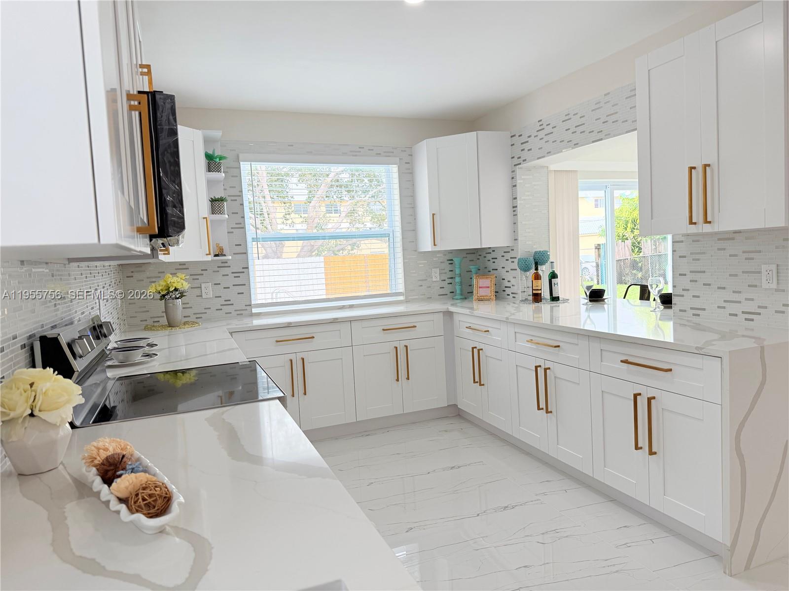 4241 Thomas Street Hollywood, FL 33021 - Photo 35 of 91 a kitchen with white cabinets and window